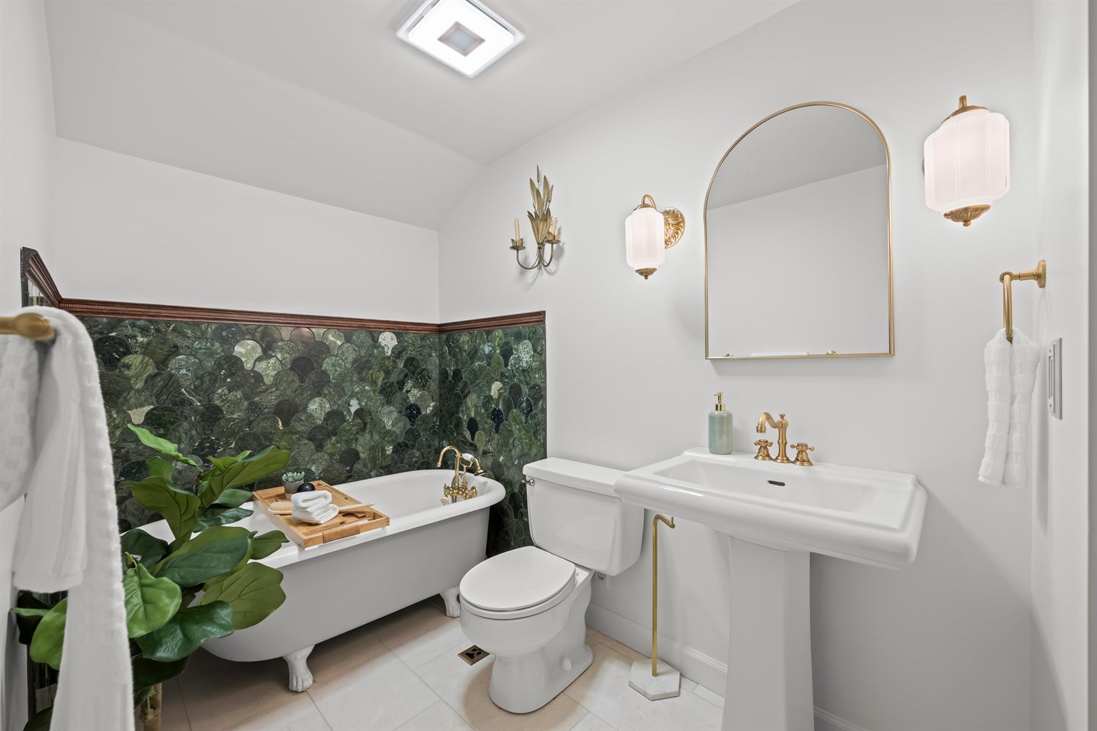 Upstairs bathroom after remodeling by SR Contractor LLC: freestanding clawfoot tub against a green scalloped marble tile wainscot, brass fixtures and a pedestal sink.